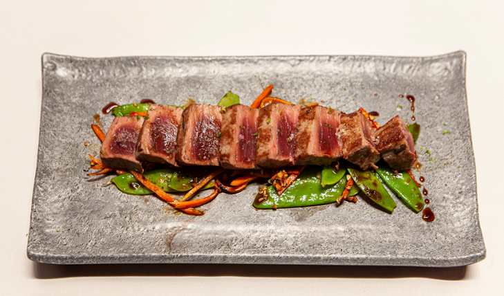 Foto de Tataki de Bonito del Norte sobre verduras al wok y anacardos